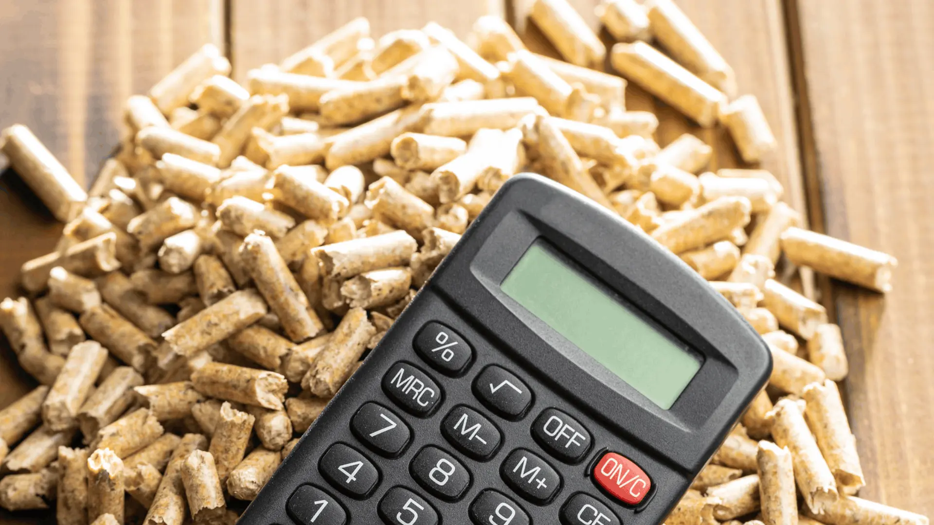 Taschenrechner auf einem Haufen Holzpellets